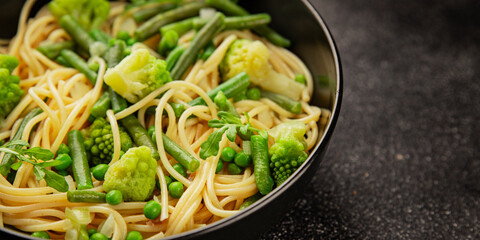 Spaghetti vegetables green peas, broccoli, string beans, kohlrabi vegetarian pasta tasty snack fresh delicious gourmet food background on the table rustic top view copy space vegan food