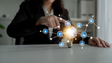 A business professional interacts with a digital interface representing innovation and connectivity. The light bulb symbolizes ideas and creative solutions in work environments. Tessel