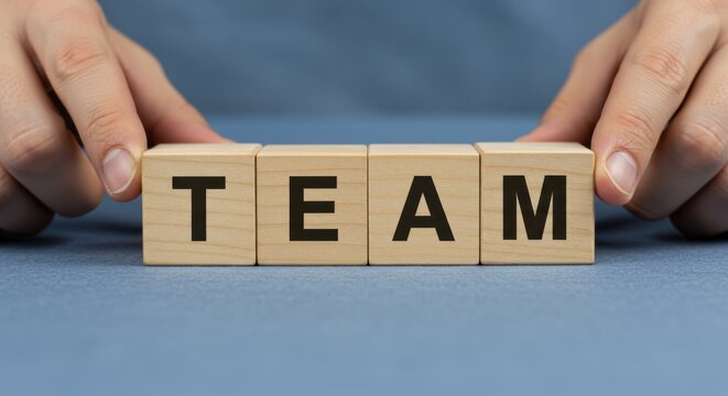 Building a strong team is essential for success; wooden blocks spell out the word TEAM