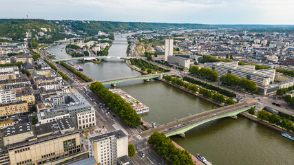 Aerial view of Rouen, France, with the Gothic Rouen Cathedral dominating the skyline, surrounded by historic half-timbered houses, the Seine River, and charming old town streets