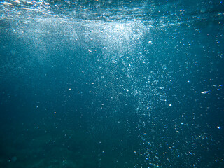 Underwater bubbles background, Real photo of  air bubble under the sea, Light and sunlight underwater in ocean and sea, Abstract oxygen bubbles rising in water surface, Sun light rays undersea deep.
