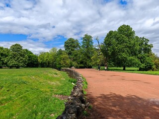 Park pathway with stone wall and people walking