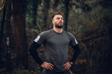 Determined athlete resting during trail running in forest