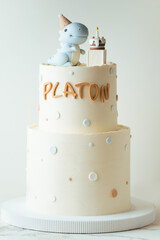 Beautiful two tier birthday cake for a little boy named Platon on the white background