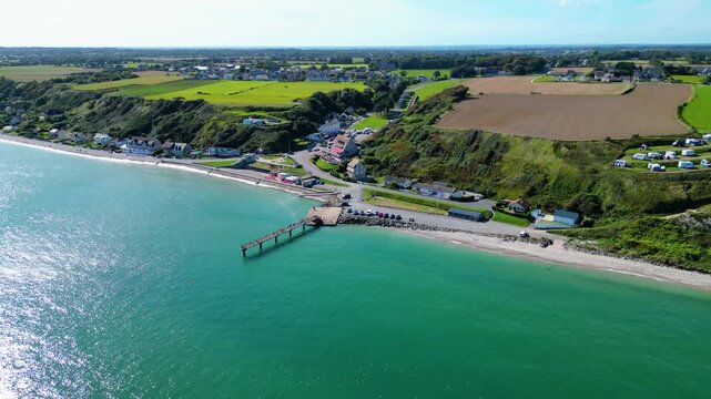 Aerial view of Omaha Beach in Normandy, France, with Flower Camping Omaha Beach nearby, historic WWII D-Day landing site, sandy coastline, green fields, and holiday atmosphere