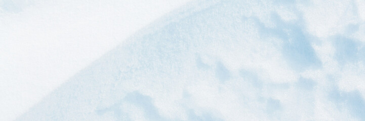 Fototapeta premium Wide panoramic winter background with snowy ground. Natural snow texture. Wind sculpted patterns on snow surface.