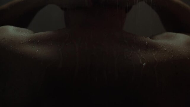 A middle-aged man stands under a tropical shower in his own bathroom. Warm drops slowly flow down his skin, creating a feeling of relaxation. He takes a shower, following his usual hygiene procedure