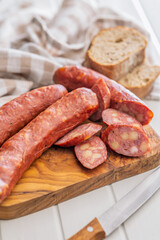 Sliced smoked ​​sausage on cutting board.