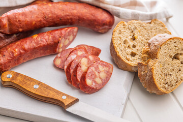 Sliced smoked ​​sausage on cutting board.