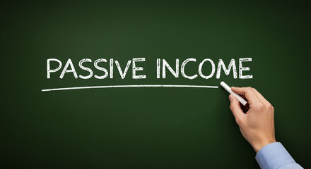 Hand writing "Passive Income" in chalk on a dark green chalkboard.