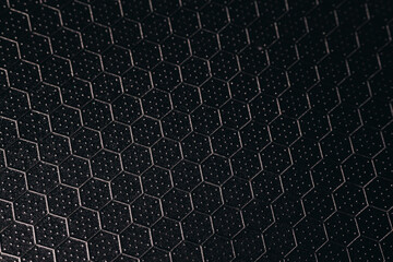 Close-up of a textured hexagonal pattern on a dark metallic surface with subtle dotted detailing,...