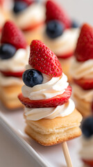 Festive Fruit Skewers: Miniature desserts with layers of cake, creamy frosting, fresh strawberries, and blueberries for a delightful treat.