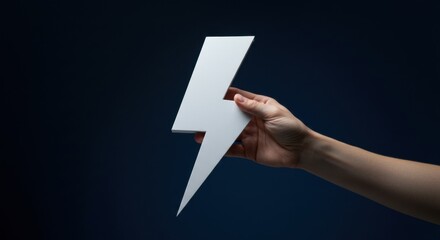Woman hand holding large white lightning bolt symbol against a dark background. Energy, power, and innovation concept for marketing and advertising.
