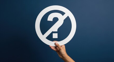Cropped caucasian hand holds a white no question mark sign on a navy blue background. Uncertainty and confusion concept for clear answers.