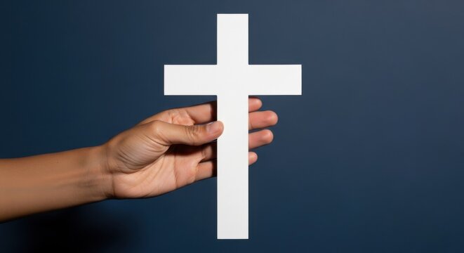 Woman hand holding a white cross on a blue background. Religious spiritual concept for faith, hope, and worship on Easter. - Powered by Adobe
