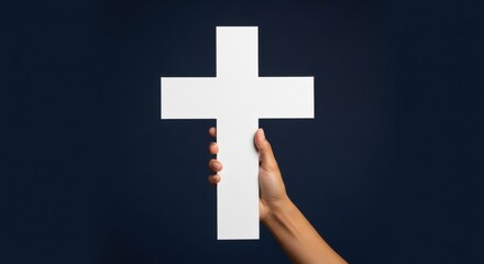 Obraz premium Woman hand holding large white Christian cross. Religious symbol of faith, belief, hope, and prayer for church or spiritual concepts.