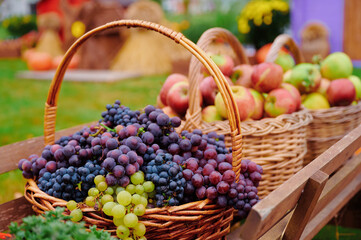 Fresh grapes and apples in outdoor baskets