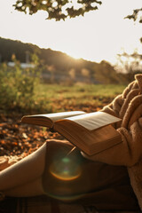 Fototapeta premium Reading a book outdoors on a sunny autumn day