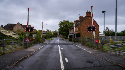 Railroad crossing gates closing with flashing lights in United Kingdom