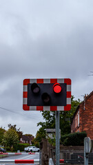 Red traffic light showing at a railroad crossing, signaling danger and preventing accidents in a cloudy day