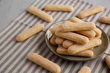 Savoiardi biscuits on a plate, side view.