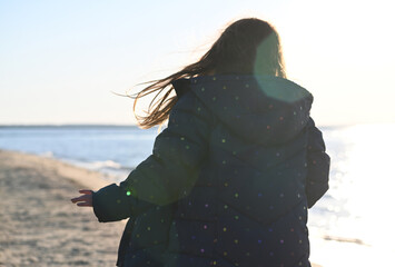 Back of  young girl child running on beach at sunset back
