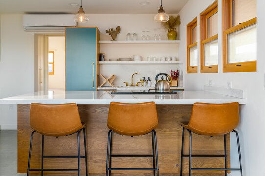Minimal modern kitchen with leather breakfast bar stools in desert home