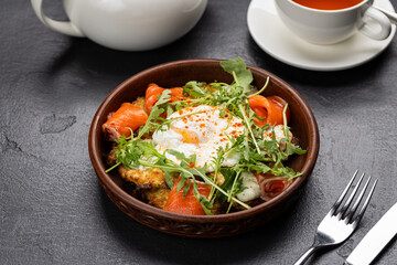 Healthy brunch with poached egg, smoked salmon and fresh arugula on a vegetable fritter