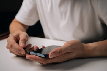 Technician removing broken tempered glass screen protector from smartphone using specialized tool, highlighting process of phone repair and maintenance. Concept of mobile phone service.