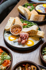Traditional English breakfast with eggs, sausages, beans, bacon, and fresh bread on plate