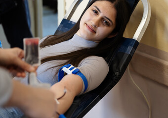 Young woman donates blood at local donation center