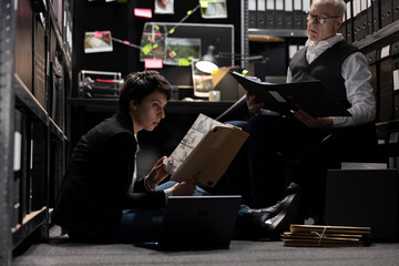 Female law officer working hard on tracing connections for the case, teamwork with experienced...