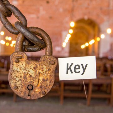 Rusty padlock with a key sign, old building