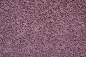 Closeup of plastered exterior wall of mauve color. Textured background.