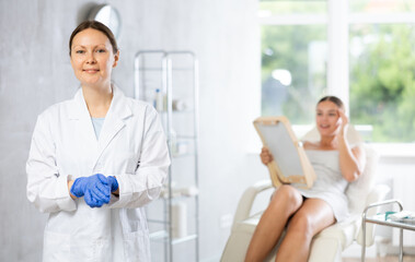 Obraz premium Adult woman cosmetologist in uniform posing in medical room