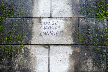 graffiti on a brick wall reading change, change, change with exclamation points