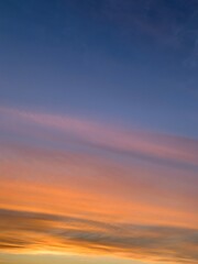 Beautiful colorful sunset sky with vibrant orange and purple clouds above dark forest silhouette