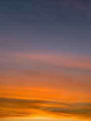 Beautiful colorful sunset sky with vibrant orange and purple clouds above dark forest silhouette
