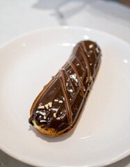 French Chocolate &Eacute;clair Pastry with Cream Filling Served on White Plate for Premium Dessert Object and Gourmet Food Concept