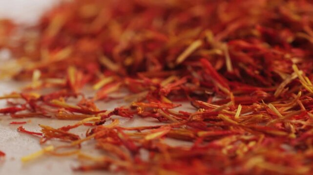 Dried crimson saffron on grey desk close-up macro. Orange red spice for food. Crocus sativus flower saffron