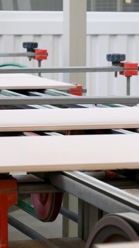 Ceramic tile production line inside industrial plant. Raw clay processed into durable surface. Conveyor transports tiles through factory. Heavy industry and construction material manufacturing