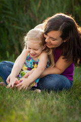 Fototapeta premium Happy Young Mother and Little Daughter Playing Together Outside