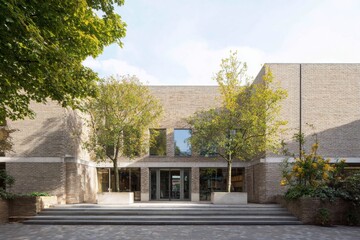 Naklejka premium Modern architecture showcases a welcoming entrance with trees and clear blue skies at a public building in a vibrant community