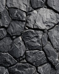 Detailed monochrome pattern of irregular stacked rocks forming a solid wall surface.