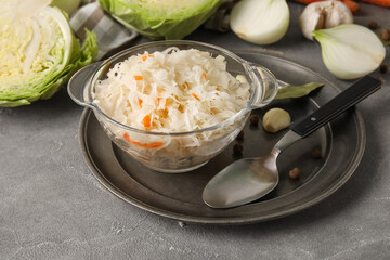 Tasty sauerkraut and ingredients on table