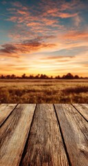 Rustic wooden deck overlooking golden field at vibrant sunset sky.