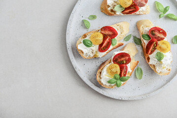 Bruschetta sandwiches with tomatoes, cream cheese, olive oil and basil