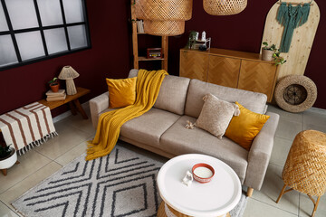 Interior of stylish living room with cozy grey sofa, coffee table and wicker lamps