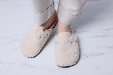 Woman in soft slippers on white marble floor, closeup