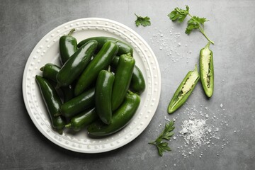 Ripe green jalapeno peppers, parsley and salt on grey table, flat lay